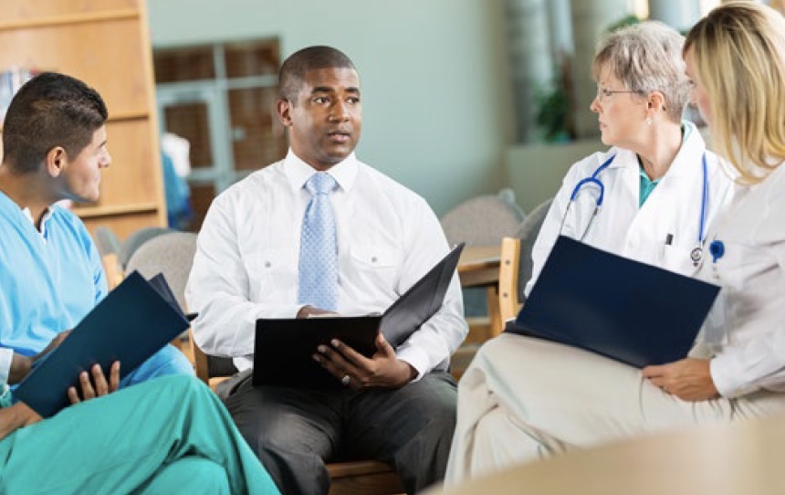 Healthcare professionals sitting in a circle discussing a case