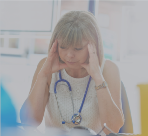 Blonde nurse with her head in her hands. 